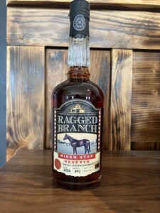 Bottle of Ragged Branch Risen Star 2026 on wood with wood in the background