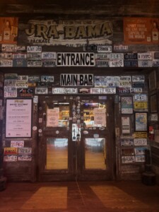 Flora-Bama entrance to the main bar showing doors and wall covered in signs